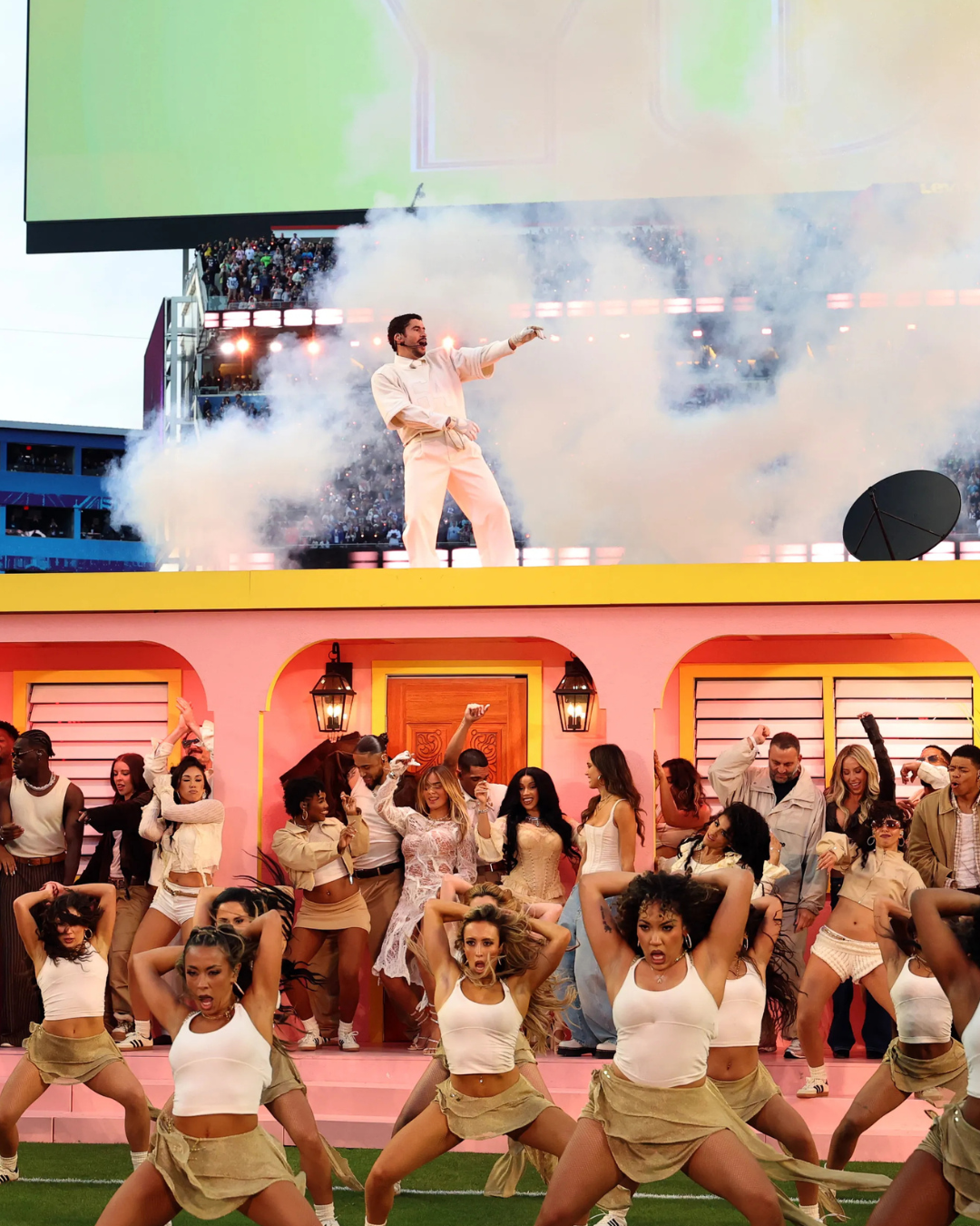 Bad Bunny Super Bowl halftime-show: groots dansensemble voor La Casita terwijl Bad Bunny bovenop het podium staat, met tientallen performers in een kleurrijk Puerto Ricaans decor.